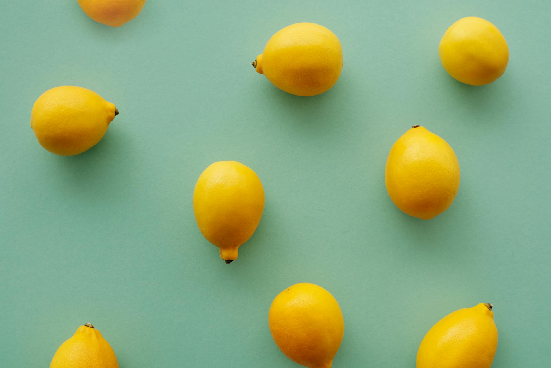 Bright yellow lemons arranged on a pastel background, symbolizing fresh approaches to pleasure during hormonal transition.