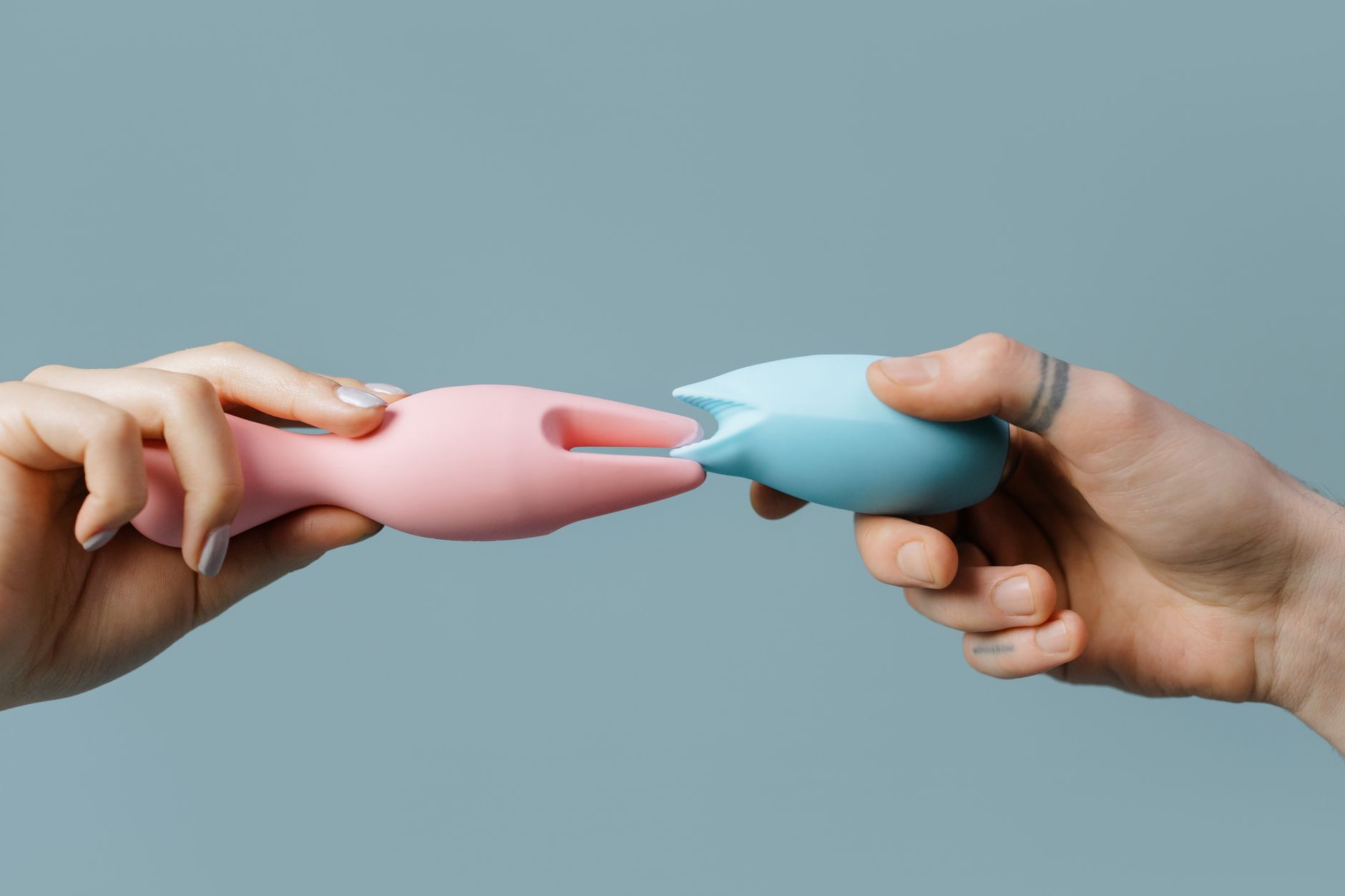 Woman holding a pink vibrator with art books in the background