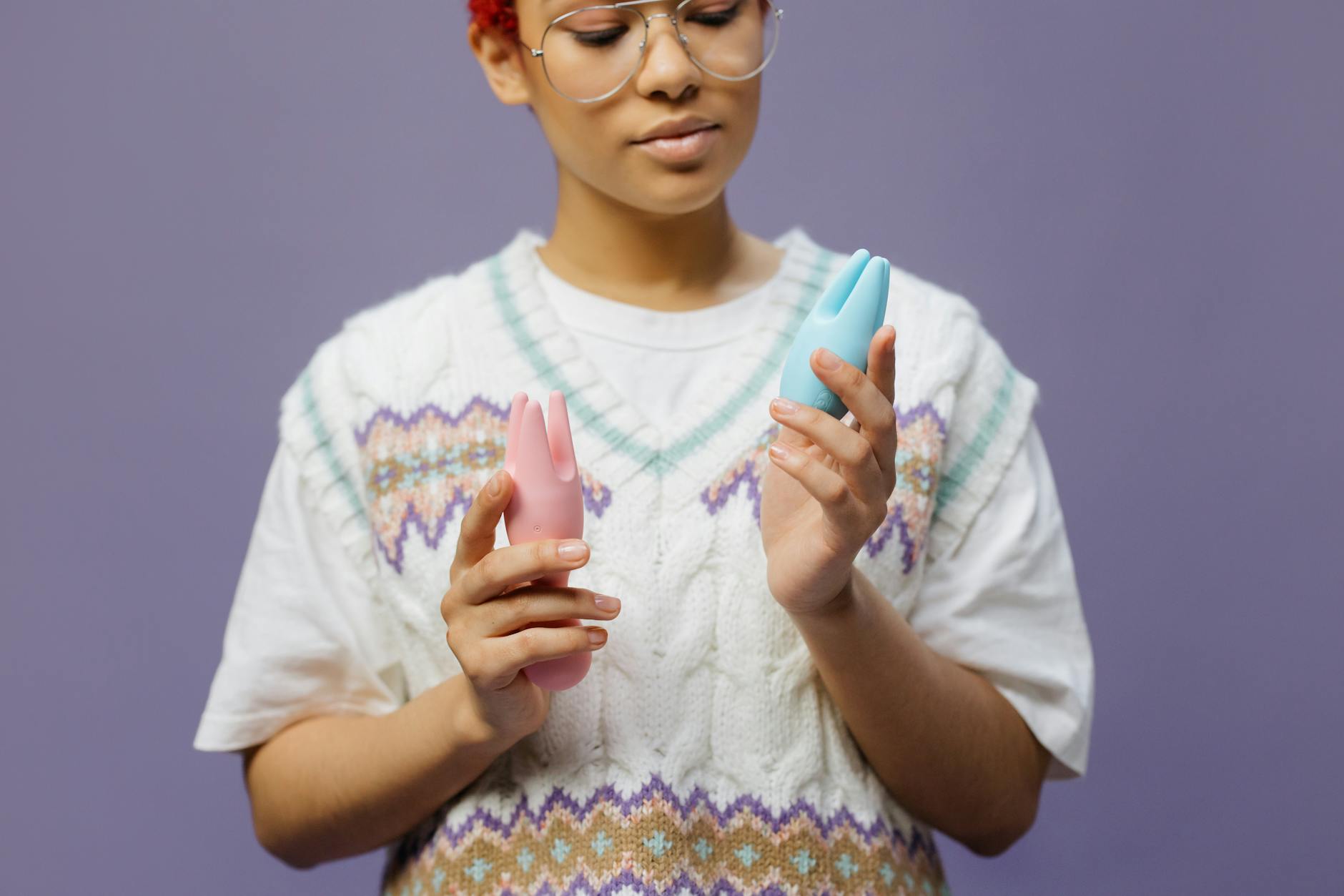 Woman holding colorful silicone vibrators, exploring sensation and pleasure