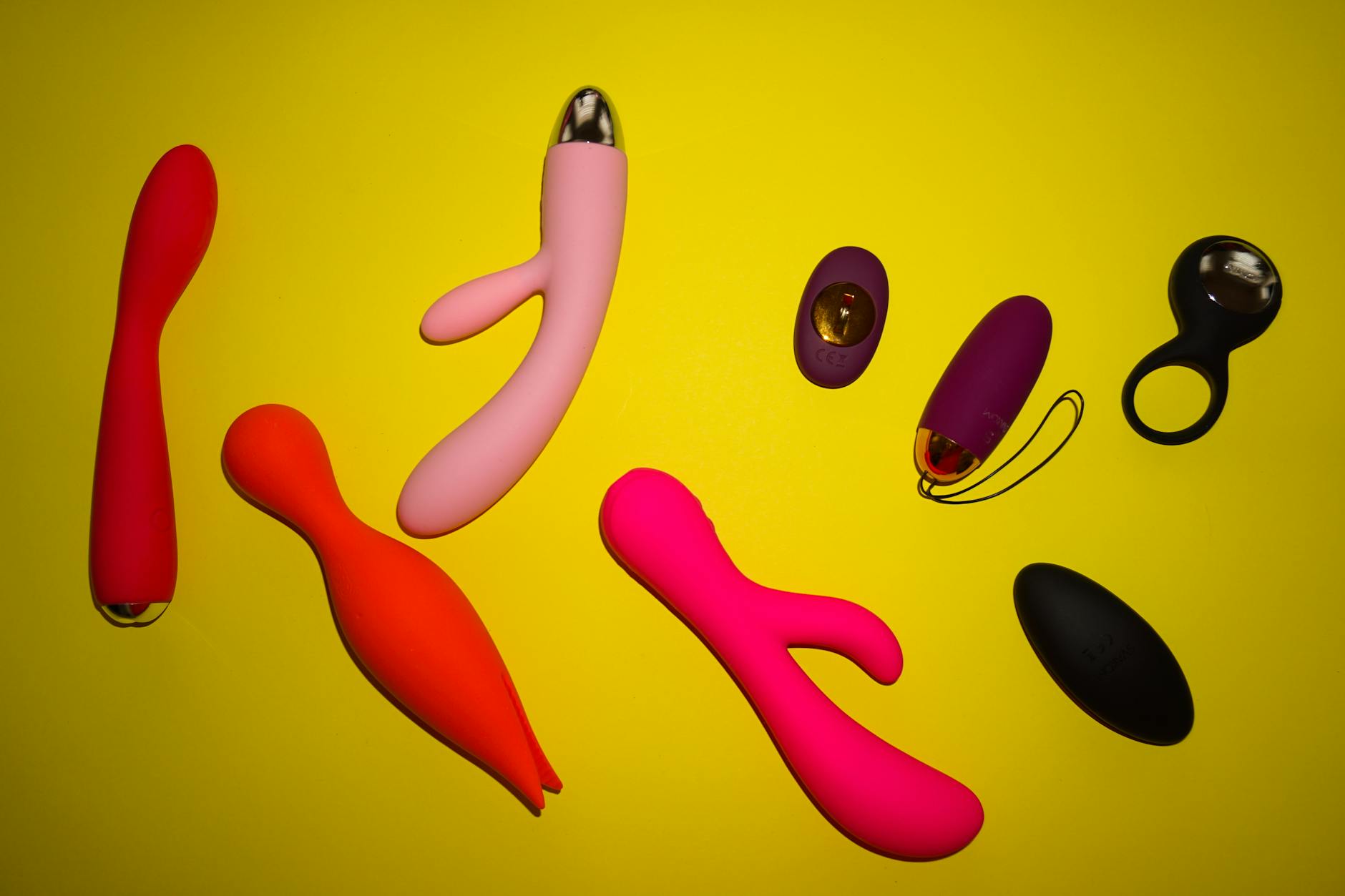 Colorful vibrators arranged on bright yellow surface